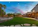 Lush backyard with stone paver walkway, manicured lawn, and covered patio at 4223 N St Elias --, Mesa, AZ 85215