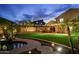 Backyard with a pool and spa, lush grass, covered patio, and perimeter string lights at 4223 N St Elias --, Mesa, AZ 85215