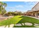 Expansive backyard with pool, covered patio, outdoor kitchen, lush lawn, and mature landscaping at 4223 N St Elias --, Mesa, AZ 85215