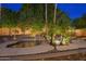 Landscaped backyard features a pool with rock accents and lush plantings at 4223 N St Elias --, Mesa, AZ 85215