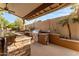Outdoor kitchen with built-in grill, stone accents, and bar seating for upscale outdoor entertaining at 4223 N St Elias --, Mesa, AZ 85215