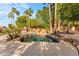Serene swimming pool area with rock waterfall, lush landscaping, and mature palm trees at 4223 N St Elias --, Mesa, AZ 85215