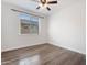 Bright bedroom features wood-look floors, ceiling fan, and sunlit windows at 4360 N 186Th Ln, Goodyear, AZ 85395