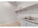 Bright laundry room with a stainless steel sink, tile floors and plenty of storage space at 4360 N 186Th Ln, Goodyear, AZ 85395