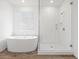 Bright bathroom with a large shower, soaker tub and wood-look tile flooring at 4777 W Hunter Trl, San Tan Valley, AZ 85144
