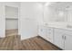 Bathroom with double sinks, wood-style flooring and access to walk-in closet at 4777 W Hunter Trl, San Tan Valley, AZ 85144
