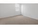 Minimalist bedroom with neutral carpet, white walls, and a window with bright, natural light at 4777 W Hunter Trl, San Tan Valley, AZ 85144