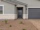 Close up on a single-story home's front door and garage, featuring manicured gravel landscaping at 4777 W Hunter Trl, San Tan Valley, AZ 85144