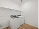 Bright laundry room with wood-style floors and a modern washer and dryer at 4777 W Hunter Trl, San Tan Valley, AZ 85144