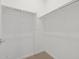 A simple walk-in closet featuring white walls and shelving, plus a beige carpet at 4777 W Hunter Trl, San Tan Valley, AZ 85144