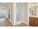Bathroom featuring a glass-block shower and a vanity with tan cabinets at 5557 W Mine Trl, Phoenix, AZ 85083