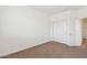 Bright bedroom featuring neutral carpet, closet, and an open doorway at 5557 W Mine Trl, Phoenix, AZ 85083