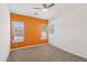 Bright bedroom with orange accent wall, carpet and multiple windows at 5557 W Mine Trl, Phoenix, AZ 85083
