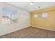 Bright bedroom with a large window, carpet and yellow accent wall at 5557 W Mine Trl, Phoenix, AZ 85083