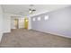 Spacious living room with a ceiling fan, gray carpet and large open entry at 5557 W Mine Trl, Phoenix, AZ 85083