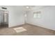 Clean bedroom with neutral carpet, white walls, ceiling fan, and view into the hallway at 6722 E El Paso St, Mesa, AZ 85205
