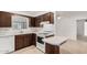Bright kitchen featuring white appliances, dark wood cabinets, and tiled floors at 6722 E El Paso St, Mesa, AZ 85205