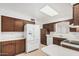 Functional kitchen with white appliances, wooden cabinets, and natural light from above at 6722 E El Paso St, Mesa, AZ 85205