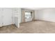 Spacious living room with neutral carpet, large window, and adjacent built-in shelving at 6722 E El Paso St, Mesa, AZ 85205