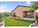 Beautifully landscaped backyard features artificial grass, a covered patio, and a built-in barbecue area at 7070 W Andrea Dr, Peoria, AZ 85383