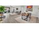 Open-concept dining area with modern table, gray chairs, and a view into the living room at 7070 W Andrea Dr, Peoria, AZ 85383