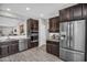 Bright kitchen with stainless steel refrigerator, granite counters, and a view into the living space at 7070 W Andrea Dr, Peoria, AZ 85383