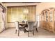 Elegant dining area with a chandelier, large window, and a stylish cabinet for storage at 7252 E Edgewood Ave, Mesa, AZ 85208