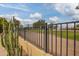 Black wrought iron fence with desert plants and community park in background at 7252 E Edgewood Ave, Mesa, AZ 85208