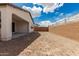 Unlandscaped backyard featuring a covered patio, block fence, and endless possibilities at 7342 W Hedge Hog Pl, Peoria, AZ 85383