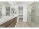 Modern bathroom with double sink vanity, walk-in shower with glass door, and walk-in closet at 7342 W Hedge Hog Pl, Peoria, AZ 85383