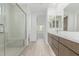 Bright bathroom with a frameless glass shower and modern double sink vanity with light wood floors at 7342 W Hedge Hog Pl, Peoria, AZ 85383