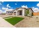Charming single-story home featuring lush synthetic grass, desert landscaping, and a brick driveway at 7342 W Hedge Hog Pl, Peoria, AZ 85383