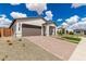 A one-story home on a beautiful day with desert landscaping and a brick driveway at 7342 W Hedge Hog Pl, Peoria, AZ 85383