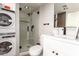Bathroom featuring a shower with glass doors and a stacked washer/dryer appliance at 7740 E Heatherbrae Ave # 13, Scottsdale, AZ 85251