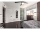 Bedroom with dark wood floor, brick accent wall, closet with glass doors, and a large window at 7740 E Heatherbrae Ave # 13, Scottsdale, AZ 85251