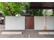 Building exterior with gated entrance, parking spaces marked, and mature shade trees at 7740 E Heatherbrae Ave # 13, Scottsdale, AZ 85251