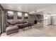 Open-concept living space with exposed brick, a sectional sofa, bar seating, and modern kitchen at 7740 E Heatherbrae Ave # 13, Scottsdale, AZ 85251