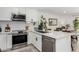 Renovated kitchen boasts stainless steel appliances, white cabinets, quartz countertops, and tile backsplash at 8113 E Vista Dr, Scottsdale, AZ 85250