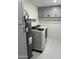 Practical laundry room with modern washer, dryer, upper cabinets, and water heater at 8113 E Vista Dr, Scottsdale, AZ 85250