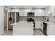Modern kitchen featuring white cabinetry, stainless steel appliances, a stylish backsplash, and a functional island at 8132 W Earll Dr, Phoenix, AZ 85033