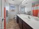 Bathroom with vanity, basin sink, mirror and a combination shower and tub with orange shower curtain at 11183 W Tonto St, Avondale, AZ 85323