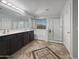 Bathroom with large vanity, dual sinks, soaking tub, and glass shower enclosure with decorative tile flooring at 11183 W Tonto St, Avondale, AZ 85323