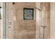 Modern bathroom shower with beige tile surround and window offering natural light and serene views at 11935 E Casitas Del Rio Dr, Scottsdale, AZ 85255