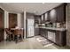 Modern kitchen with stainless steel appliances, dark wood cabinetry, and a small dining area at 11935 E Casitas Del Rio Dr, Scottsdale, AZ 85255