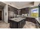 Large kitchen island with granite countertops, stainless appliances and dark wood cabinets at 11935 E Casitas Del Rio Dr, Scottsdale, AZ 85255