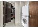 This home has a modern laundry room with closet and stacked washer and dryer at 11935 E Casitas Del Rio Dr, Scottsdale, AZ 85255