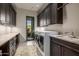 Laundry room with dark wood cabinets and utility sink, adjacent to the washer and dryer at 11935 E Casitas Del Rio Dr, Scottsdale, AZ 85255