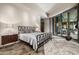 Stylish main bedroom with a unique bed frame, side tables, tile flooring, and access to an outdoor patio at 11935 E Casitas Del Rio Dr, Scottsdale, AZ 85255
