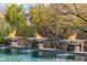 Inviting pool area featuring fire bowls and lush landscaping at 11935 E Casitas Del Rio Dr, Scottsdale, AZ 85255