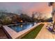 Tranquil pool area with a fire feature, turf, and mountain views at sunset at 11935 E Casitas Del Rio Dr, Scottsdale, AZ 85255
